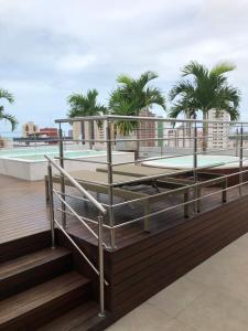 若昂佩索阿Manaíra Apart Hotel - Flat 201的一个带游泳池和棕榈树的屋顶甲板