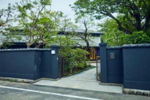 福生市ゲストハウス酒坊多満自慢的房屋前的蓝色围栏