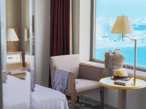 稚内Surfeel Hotel Wakkanai的酒店客房设有椅子、桌子和窗户。