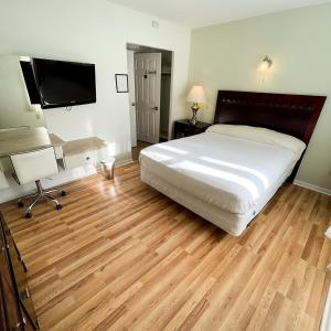 库珀斯敦Baseball Town Motel的一间卧室配有一张床和一台平面电视