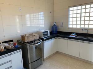 AlexâniaCasa de Campo em Alexania GO - Bela Vista do Corumbá的厨房配有白色橱柜和炉灶烤箱。