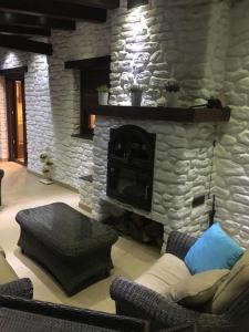 特雷韦莱斯Hostal Mulhacen的客厅设有石制壁炉和沙发。