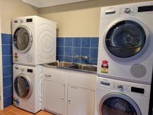 纽卡斯尔Blue Wren Lodge Waratah的厨房配有2台洗衣机和水槽