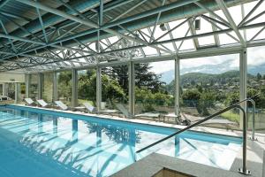 施皮茨Hotel Eden Spiez的一个带椅子的游泳池,享有山景