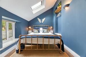 奥特本Host & Stay - Percy Cottage的一间拥有蓝色墙壁的卧室和一张位于客房内的床