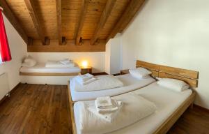 安德马特Berggasthaus Piz Calmot的配有木天花板的客房内的两张床