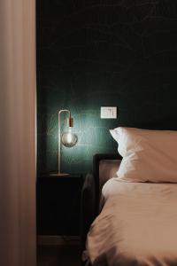 科莫Casa LiLu by Comorooms的一间卧室设有绿色的墙壁、一张床和一盏灯