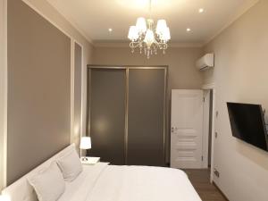 利耶帕亚MARBEO 5 Star Luxury Suites - Peldu的卧室配有白色的床和吊灯。