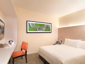 雪邦萨玛萨玛KLIA2快捷酒店（航空中转酒店） 的配有一张床和一把椅子的酒店客房