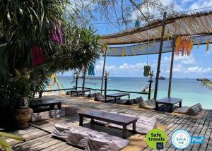涛岛AC 2 Resort的一个带长椅和海洋的木甲板