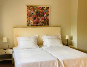 扎哈罗Rex Hotel - Bebeka's的卧室内的两张床,墙上有绘画作品