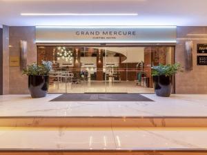 库里提巴Grand Mercure Curitiba Rayon的一间盛大的美利坚商店,窗户上放着两盆植物