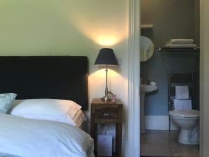 阿比莱克斯Blackhill Woods Retreat的一间卧室,配有一张床和床头灯