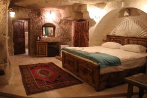 格雷梅Rose Cave Hotel的石屋设有一间带大床的卧室