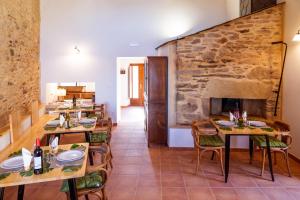 欧罗尔O Viso Ecovillage - Hotel Ecologico Vegano的一间带桌椅和石墙的用餐室