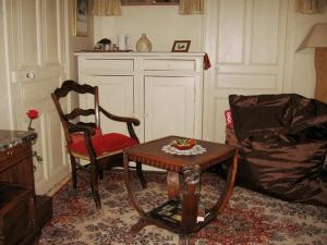 伊泽尔河畔的罗曼Sylvie BARON - Composition Française - Chambres d'hôtes的客厅配有两把椅子、一张桌子和一张沙发