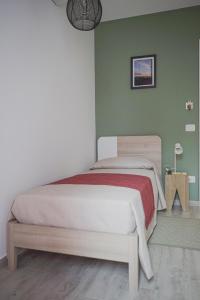 PolistenaCasa Matilde b&b的卧室设有一张位于绿色墙壁上的床铺