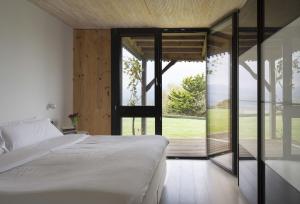 CanalaHemingway casa rural Kanala的一间卧室设有一张床和一个大型玻璃门
