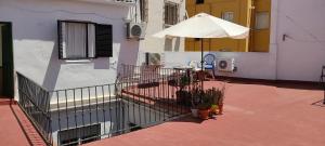 塞维利亚Apartamento para 3 en pleno centro de Sevilla的一座建筑旁的带遮阳伞的庭院