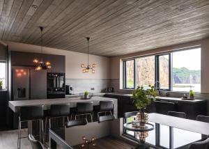 韦斯特曼纳埃亚尔Pier Apartments的厨房配有黑色椅子和木制天花板
