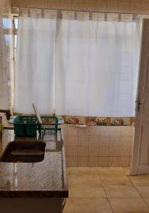 圣洛伦索Apartamento no centro的厨房配有白色窗帘和淋浴