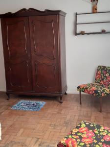 圣洛伦索Apartamento no centro的客厅配有大型木制橱柜和椅子