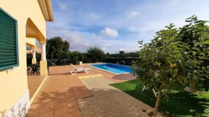 阿泽陶Casa da Vinha Azeitão的庭院中带游泳池的房子