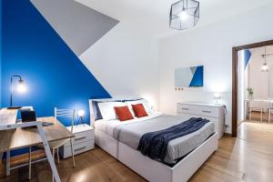 桑特伊阿Quick Home Agatha Apt的蓝色和白色的卧室配有一张床和一张书桌