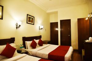 阿姆利则Hotel Sapphire Opposite Golden Temple的酒店客房 - 带两张带红色枕头的床