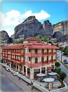 卡兰巴卡Famissi Hotel的一座大建筑,背景是一座山