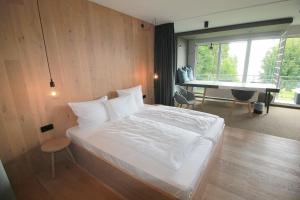 阿舍贝格Junior-Suite "Bellavista" mit Seeblick的卧室配有床、书桌和钢琴