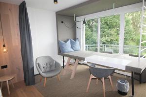 阿舍贝格Junior-Suite "Bellavista" mit Seeblick的客房设有桌椅和窗户。