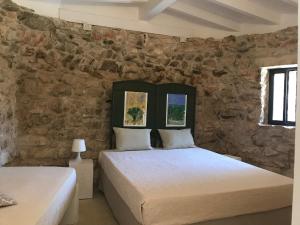 萨尔维Feudo Frammasi - Curte Glamping Experience的石墙客房的两张床