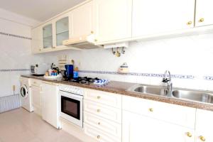 米尔芳提斯城Villa - Duna Parque Group的厨房配有白色橱柜和水槽