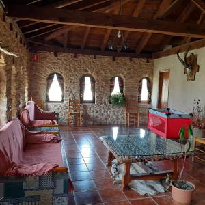Peñarroya de TastavinsMasia Del Aragones的客厅配有桌子和石墙