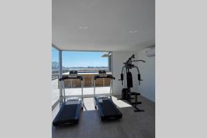 埃斯特角城La Salina Apto a estrenar a pasos del puerto的健身房设有两台跑步机和大窗户