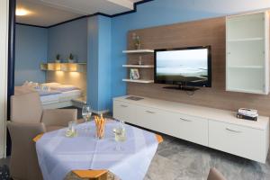 诺德奈沃特斯特朗艾尔斯酒店的客厅配有电视和桌椅