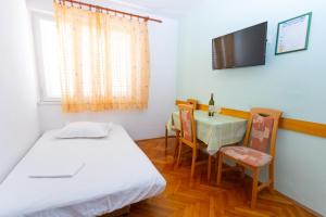 伯德古拉Apartmani Vranjes 2的配有床、桌子和电视的房间