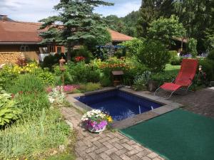 贝里斯泽尔Landhaus Renata Bayrischzell的花园内的游泳池,带椅子和鲜花