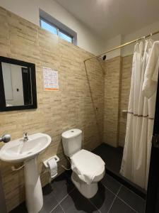 莱蒂西亚ZUGI INN HOTEL的浴室配有白色卫生间和盥洗盆。