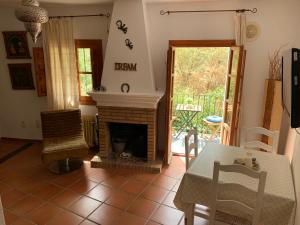 布维翁Acogedor Apartamento - La Alpujarra的客厅设有壁炉、桌子和椅子