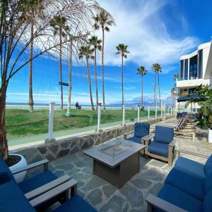 洛杉矶海滩威尼斯酒店的一个带蓝色椅子和桌子的庭院,并种植了棕榈树