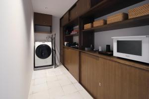 鸣泽市abrAsus hotel Fuji的洗衣房配有洗衣机、烘干机和电视。