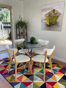 巴拉腊特Ballarat CBD Accommodation 2 Bd Townhouse Talbot Terrace的一间用餐室,配有桌椅,铺着色彩缤纷的地毯