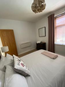 巴恩斯利Pillow Properties - Barnsley Centre的卧室配有白色的床和窗户。