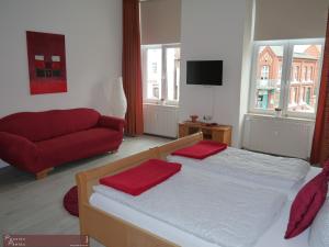 Schönberg帕松佩奥酒店的一间卧室配有一张床和一张红色的沙发