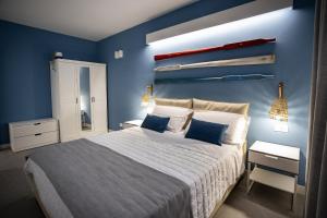 圣维托罗卡波Acquarò Suite Apartments的一间卧室配有一张带蓝色墙壁的大床