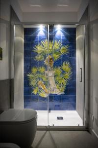 圣维托罗卡波Acquarò Suite Apartments的一间带卫生间的浴室和蓝色瓷砖墙