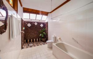 罗威那巴厘岛塔曼海滩及Spa罗维纳度假酒店的带浴缸、卫生间和盥洗盆的浴室
