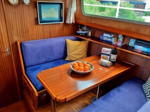 阿姆斯特丹Motor Yacht Amstelle的一张桌子,上面放着一碗橘子和一瓶葡萄酒